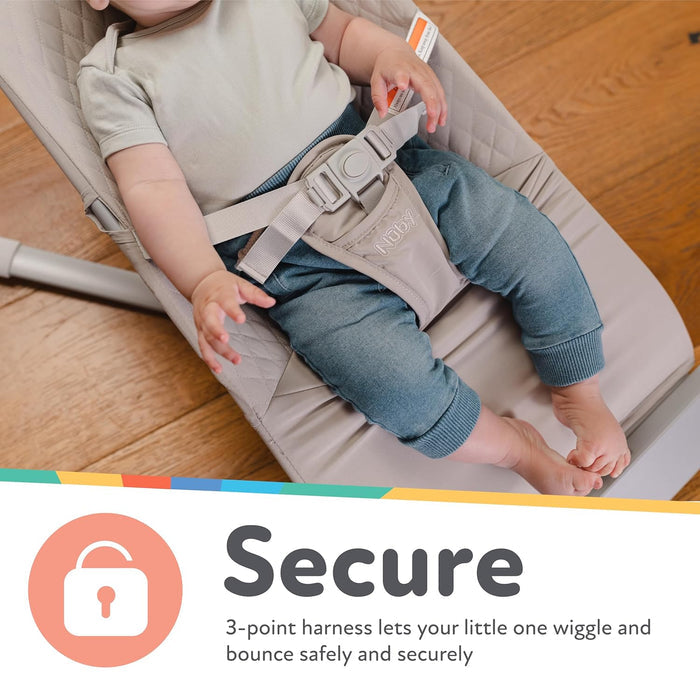 A baby enjoys the Baby Bouncer Seat | Grey, resting in its cushioned ergonomic design with a 3-point harness that keeps your little one safe while they wiggle and bounce. Text reads: Secure. 3-point harness keeps your baby safe and secure.