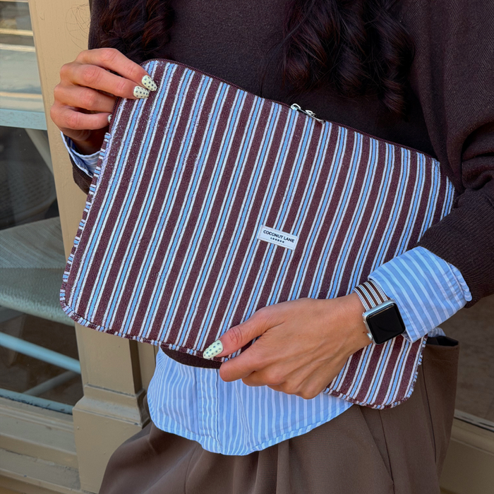 Girl holding blue and brown stripe towel laptop sleeve