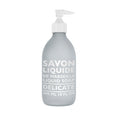 A frosted glass bottle with a pump dispenser labeled 'SAVON LIQUIDE DE MARSEILLE DELICATE', containing Delicate Liquid Soap.