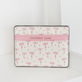 Cream vegan leather card holder with pink bow pattern, pink stripe, and gold Coconut Lane logo.