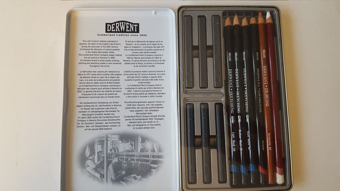 Derwent art pencils in a metal case with a leaflet on a white background
