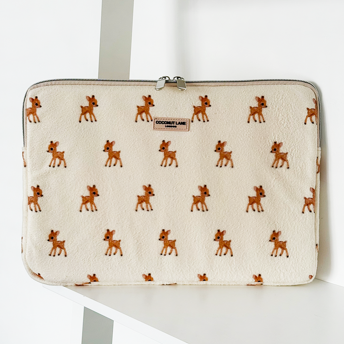 Beige fleece laptop sleeve with a pattern of small brown deer on a white background.