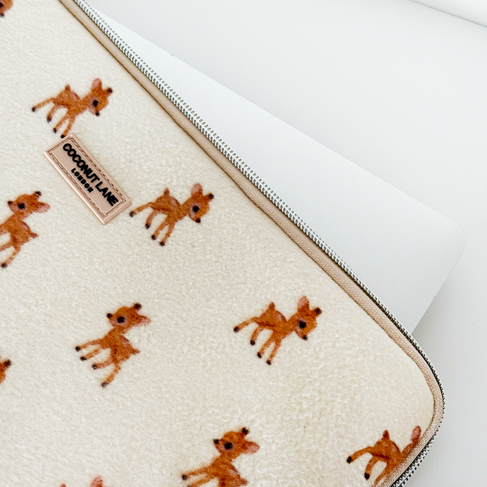 Cream fleece laptop sleeve with small deer pattern, partially unzipped over a laptop.