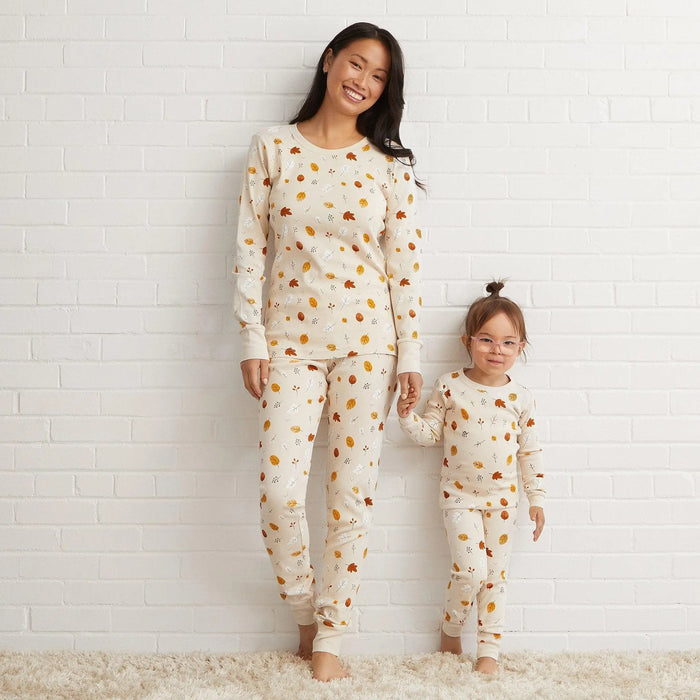 Girl wearing Petit Lem Natural Foliage pajamas in a matching family fall sleepwear photo.