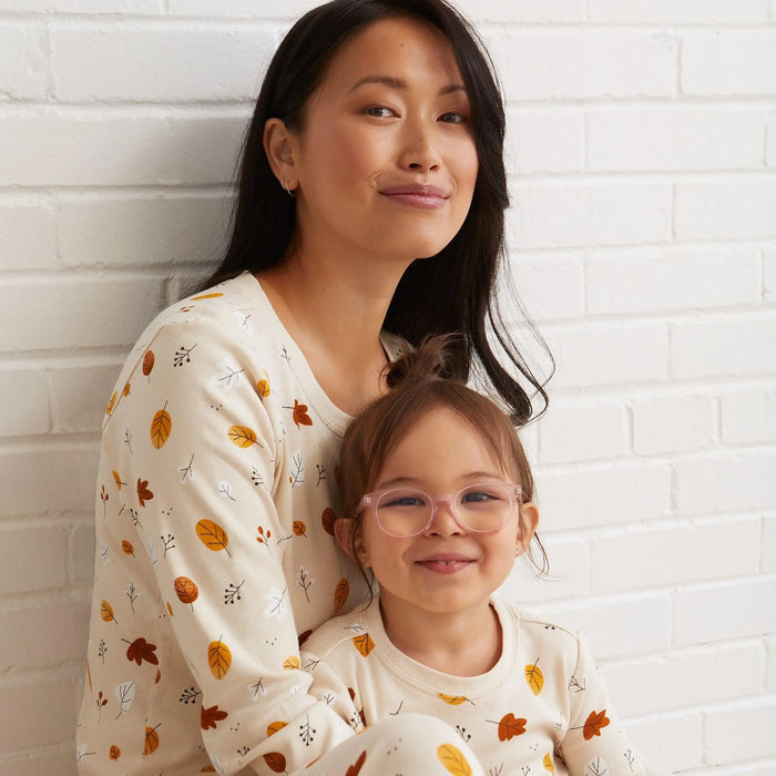 Mom and child wearing Petit Lem Foliage matching pajamas in Natural autumn leaf print.