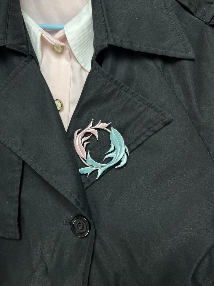 A handmade Chanhua Qiyu little fish brooch on a black coat