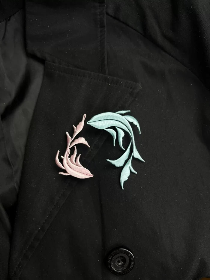 A handmade Chanhua Qiyu little fish brooch on a black coat-4