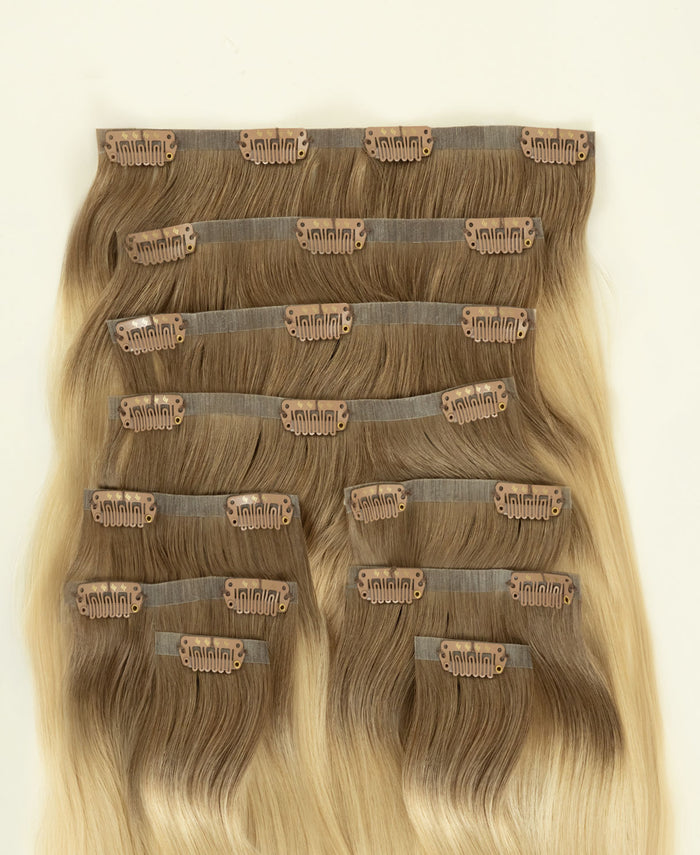 invisible clip-in hair extensions rooted blonde.