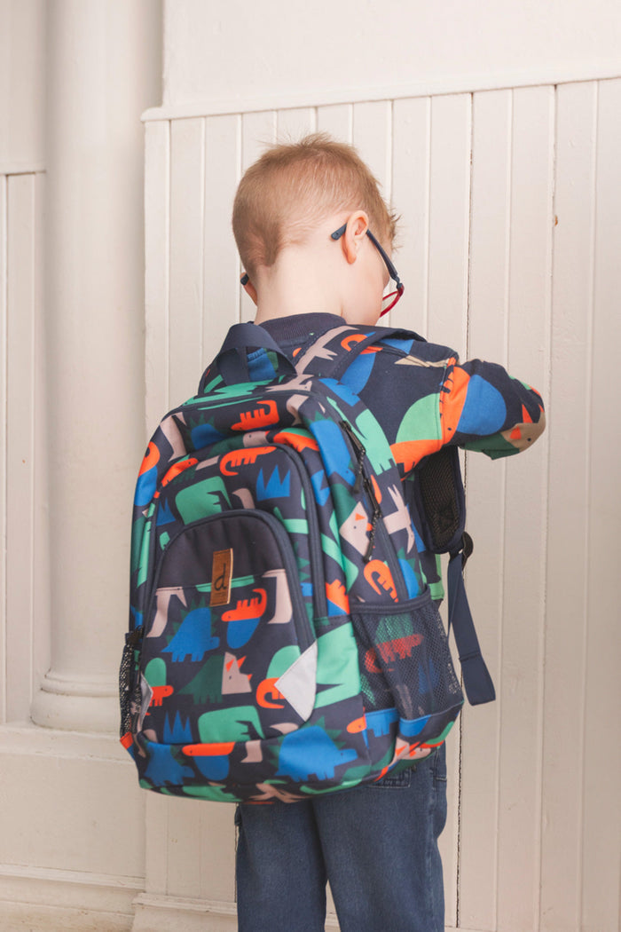 Child wearing the Navy dinosaur preschool backpack for a school-ready lifestyle look.
