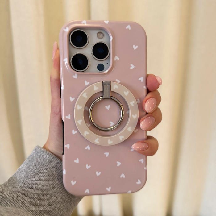 Hand holding phone with Coconut Lane MAGSAFE® Phone Ring featuring a chai-colored heart pattern.
