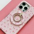 Coconut Lane Ditsy Floral Pink MAGSAFE® phone ring attached to a phone, resting on a pink surface.