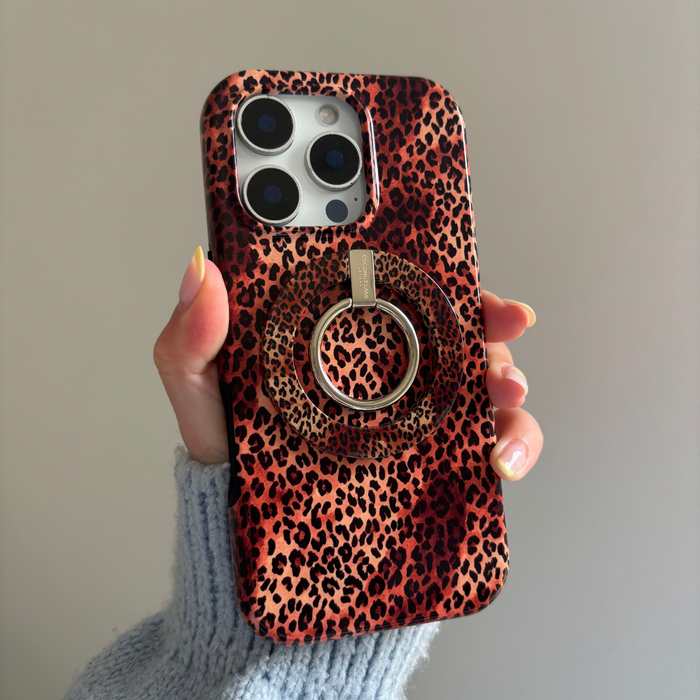 Phone with a Coconut Lane MAGSAFE® leopard-print ring on a red leopard-patterned case held in a hand.