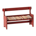 Red wooden bench with a striped cushion on a white background