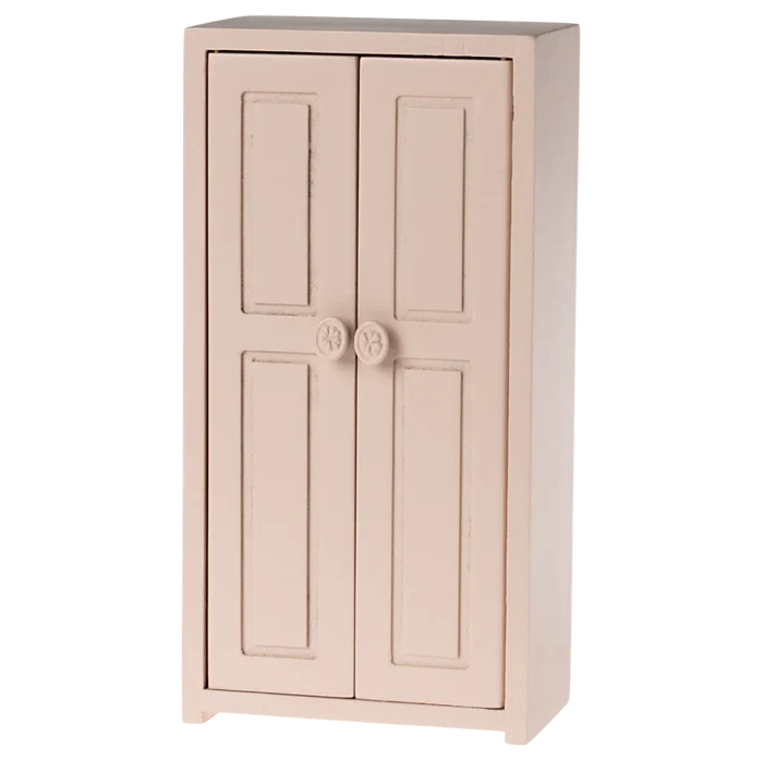 A small toy closet in a light rose color with two doors and golden hangers inside.