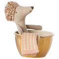 A toy mouse with a shower cap standing in a golden metal bathtub with a towel hanging on the side.