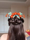 Orange - colored handmade Chanhua hair comb on a woman's hair