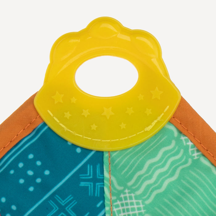 A close-up of the Plush Pal Teether Blankie | Lion, a yellow, textured baby teether with a central hole, attached to an interactive plush fabric featuring blue, green, and orange patterned sections.