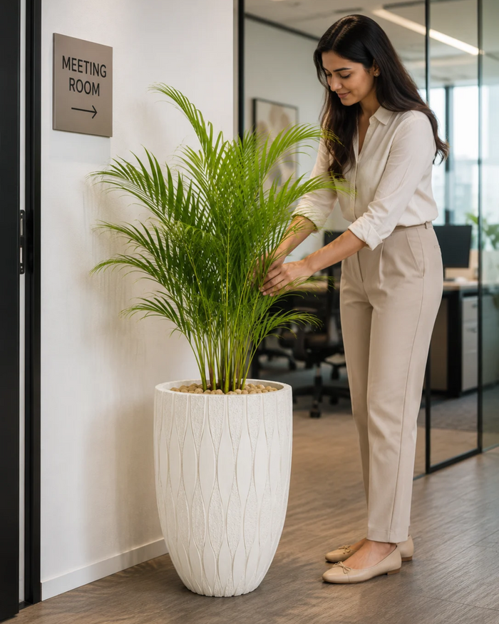 Textured leaf-pattern decorative planter with plant, white pot and vertical leaf ridges