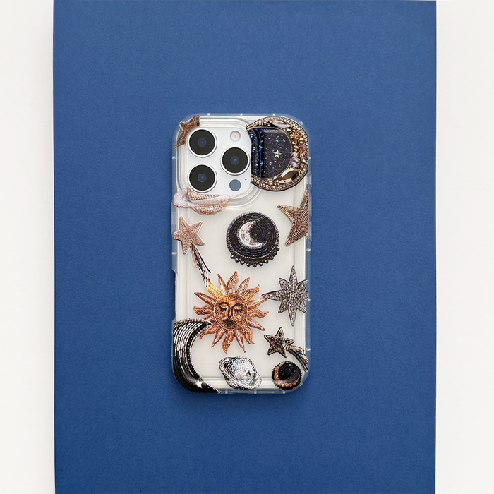 Clear phone case with gold suns, moons, and stars pattern on a deep blue background.