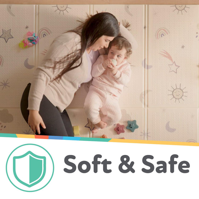 A woman gently leans over a baby lying on the Reversible Floor Mat | Safari, featuring soft padding and pastel safari designs. A green shield icon with "Soft & Safe" text highlights the mat’s safety and easy portability.