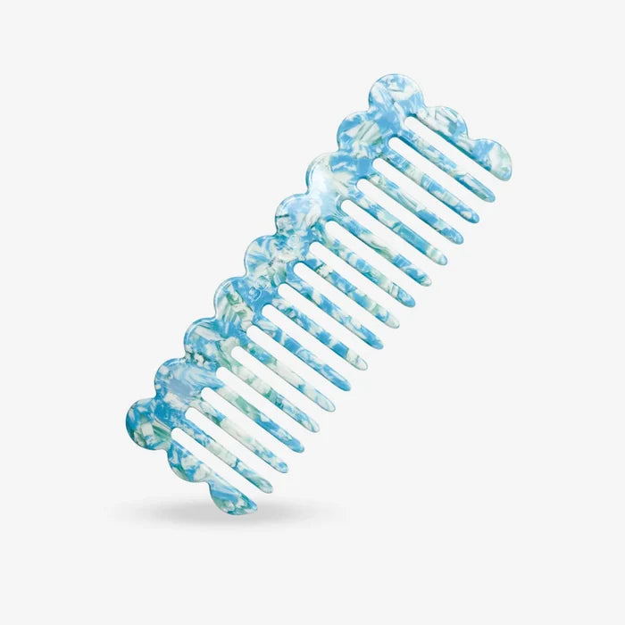 Blue and white marbled Ocean hair comb on a light gray background
