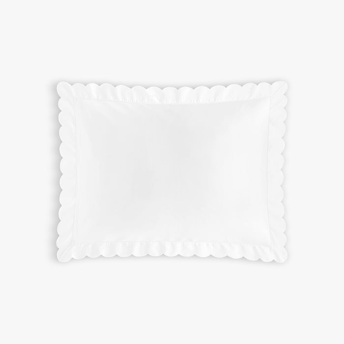 White scalloped edge pillow on a white background