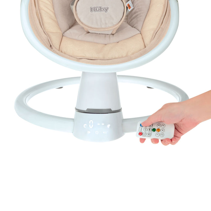 A hand holds a remote control near the base of the Nuby Smart Baby Swing & Bouncer | Beige, featuring a circular white frame and beige padding.