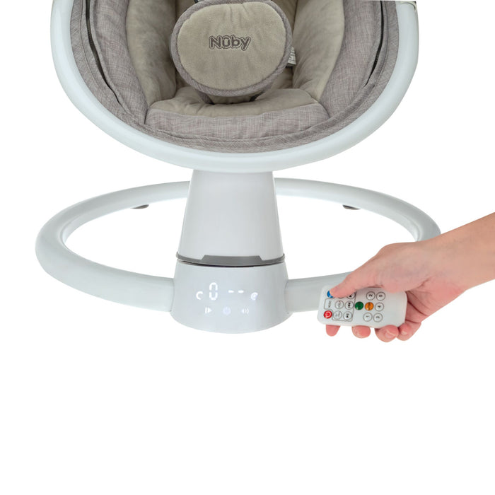 A hand holds a remote near the base of the Nuby Smart Baby Swing & Bouncer in grey, with the brand logo and control icons clearly visible on the swing’s base.