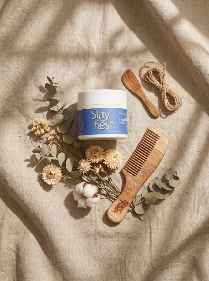 Slaykesh Hair Mask jar with wooden Neem Comb and applicator on linen