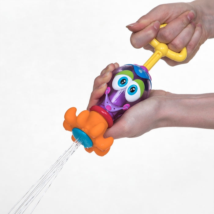 A person squeezes the Squid Squirter Water Squirter, shaped like an owl with an orange flower tip, spraying water for interactive bathtime fun.