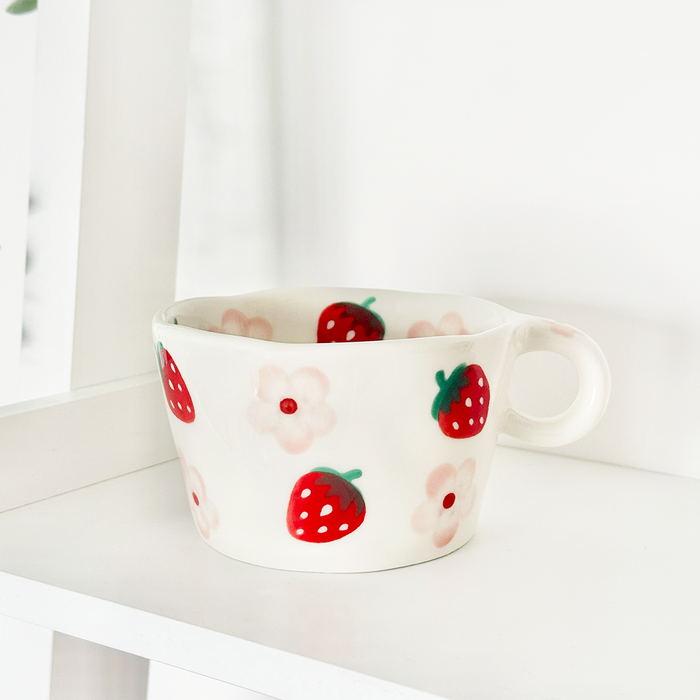 White ceramic mug with red strawberry and pink flower pattern by Coconut Lane.