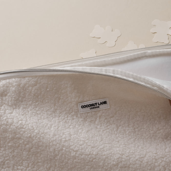 Teddy Dolly Laptop Sleeve by Coconut Lane in soft beige fabric with visible label and white cloud-shaped cutouts nearby.