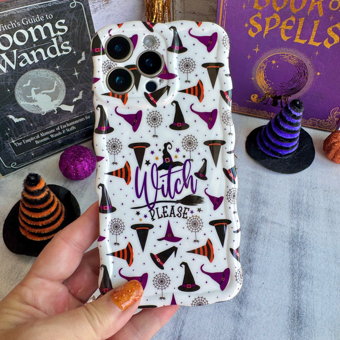 Witch Please Wavy Luxe MagSafe iPhone case held in hand, cream with purple witch hats, spiderwebs and purple script lettering.