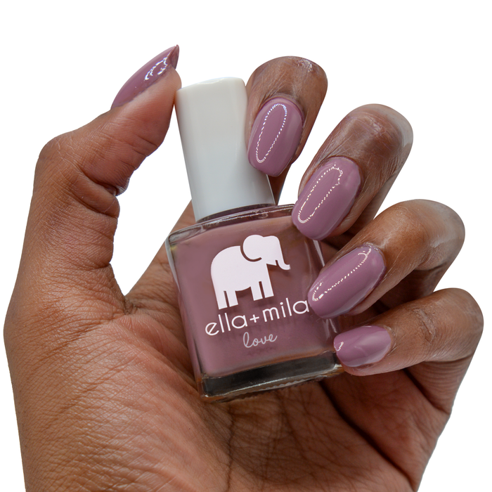 You and Me grey purple nail polish on a deep skin tone, hand holding the bottle